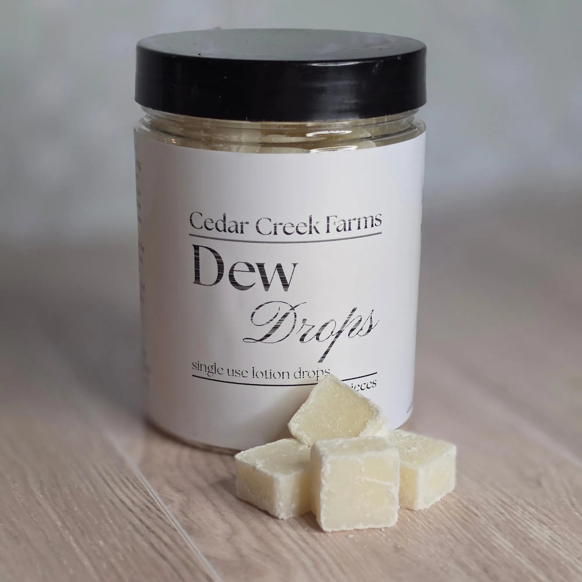 Cedar Creek Farms Dew Drop lotion drops front view with glass bottle in natural skincare setting