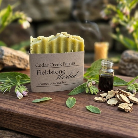 Cedar Creek Farms Fieldstone Herbal comfrey botanical soap bar with fresh herbs and tincture bottle displayed on rustic wooden board